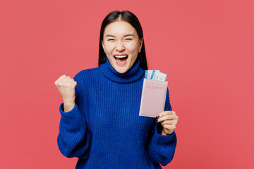 Traveler winner woman wear blue sweater casual clothes hold passport ticket isolated on plain pink...