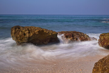 long exposure photography  of beach in northern Israel with small waves breaking on the shore
