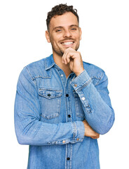Young hispanic man wearing casual denim jacket looking confident at the camera with smile with...