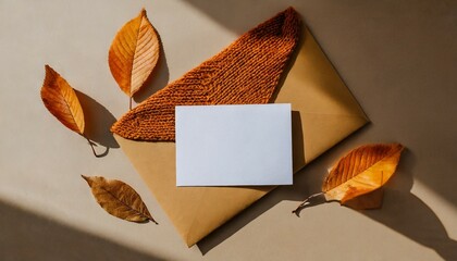 blank paper card mock up envelope brown fall leaves orange knitted textile on neutral beige background with aesthetic sun light shadow autumn business branding template wedding invitation design