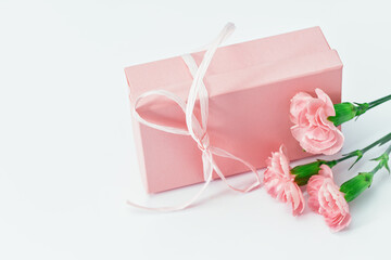 Pink gift box with tender pink carnation flowers. Gift or holiday concept. Mothers Day, birthday wedding or St Valentines day with copy space. Minimal