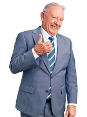 Senior handsome grey-haired man wearing elegant suit doing happy thumbs up gesture with hand. approving expression looking at the camera showing success.