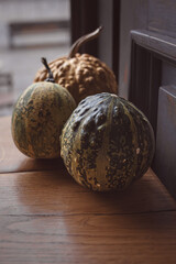 Still life of three pumpkins on a wooden table. Orange vegetables. Still life of pumpkins. Kitchen theme. Products on the table. A group of objects. Restaurant decor. Healthy diet.