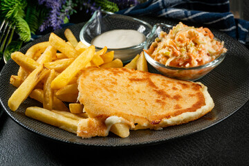 Appetizing fried cheese served with french fries, tartar sauce and salad