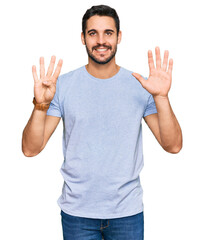 Young hispanic man wearing casual clothes showing and pointing up with fingers number nine while...