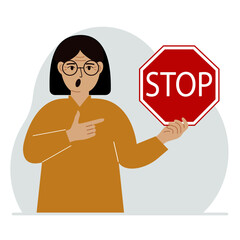 A woman holds a red stop sign in his hand.