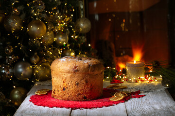 Panettone Christmas cake on a background of a Christmas tree and a burning fireplace