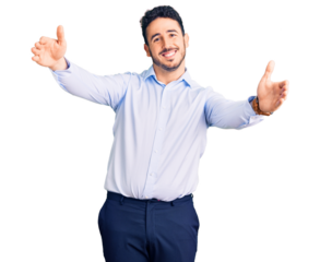 Young hispanic man wearing business clothes looking at the camera smiling with open arms for hug. cheerful expression embracing happiness.