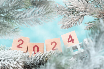 Wooden cubes with digits 2024 with Christmas tree frosty branches. Christmas and New Year holiday...