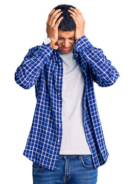 Young african amercian man wearing casual clothes suffering from headache desperate and stressed because pain and migraine. hands on head.