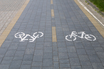 Two-lane bicycle path with painted signs and paved road tiles