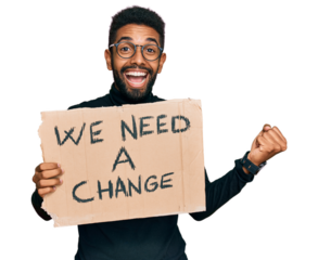 Young african american man holding we need a change banner screaming proud, celebrating victory and success very excited with raised arms