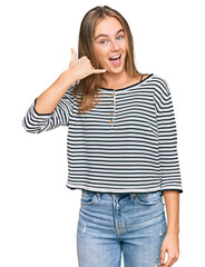 Fototapeta premium Beautiful blonde woman wearing casual clothes smiling doing phone gesture with hand and fingers like talking on the telephone. communicating concepts.