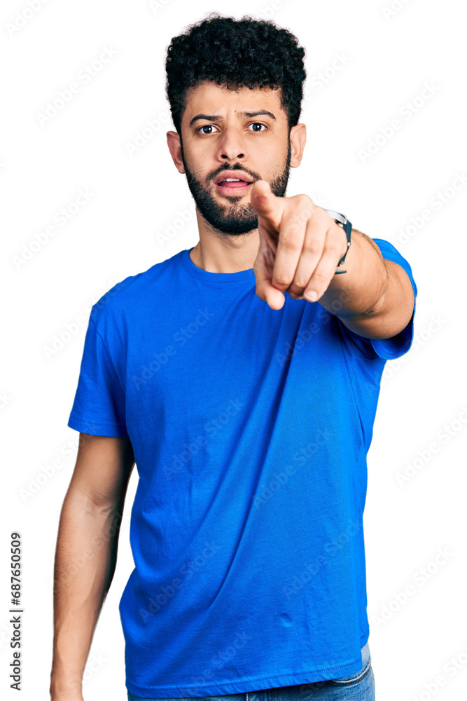 Poster Young arab man with beard wearing casual blue t shirt pointing displeased and frustrated to the camera, angry and furious with you