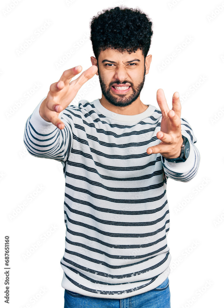 Wall mural Young arab man with beard wearing casual striped sweater shouting frustrated with rage, hands trying to strangle, yelling mad