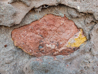 Weathered and damaged concrete wall made of cement and stones. Abstract grunge background.
