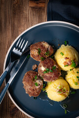 Meatballs with cheese served with boiled potatoes.