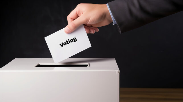 Hand casting a ballot into the election box with “Voting” written on the paper. Embrace your role in shaping democracy.