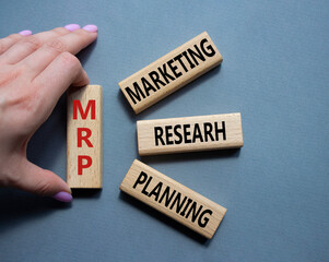 MRP - Marketing Research Planning symbol. Concept word MRP on wooden cubes. Businessman hand. Beautiful grey background. Business and MRP concept. Copy space.