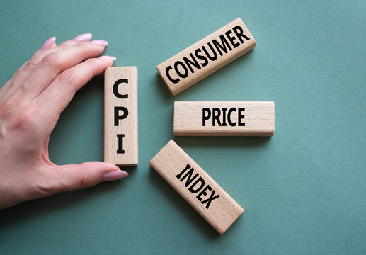 CPI - Consumer Price Index symbol. Concept word CPI on wooden blocks. Businessman hand. Beautiful grey green background. Business and CPI concept. Copy space.