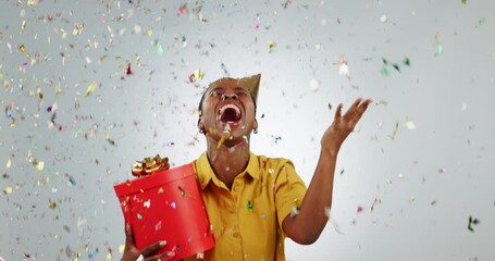 Birthday present, celebration and woman with confetti shower, prize and jump with happiness for win on white background. Gift, party and African giveaway winner, excited for bonus or reward in studio