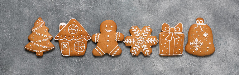 A set of gingerbread cookies in a row on a gray concrete background. Top view, flat lay.