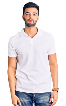 Young handsome hispanic man wearing casual clothes relaxed with serious expression on face. simple and natural looking at the camera.