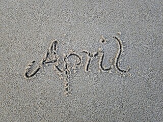 April als Wort im Strandsand