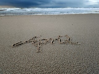 Wort April im Strandsand