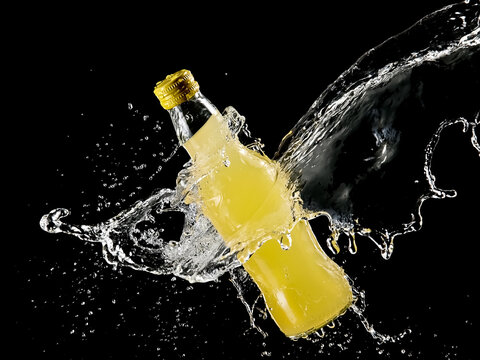 Small lemonade bottle water splash on black background