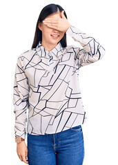 Fototapeta premium Young beautiful chinese woman wearing casual shirt smiling and laughing with hand on face covering eyes for surprise. blind concept.