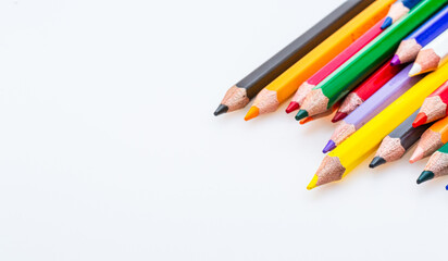 A Spectrum of Vibrant Colors: A Row of Colored Pencils on a White Background. A row of colored pencils on a white background