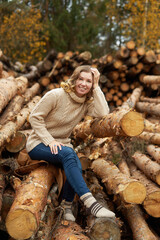 smiling woman  in front of wooden logs.