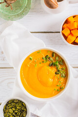Corn porridge with pumpkin puree and microgreens in a bowl on the table top and vertical view
