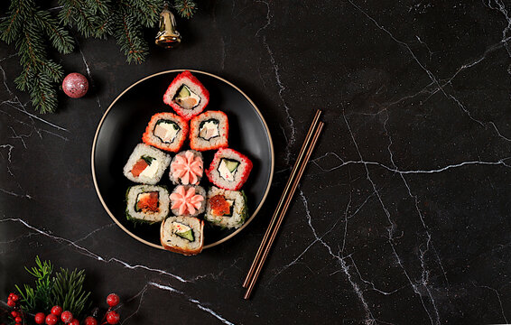 Christmas tree of fresh sushi rolls with sauce on a marble background, Christmas New Year food, banner for advertising a store, bar, menu for a cafe, traditional Japanese cuisine, place for text