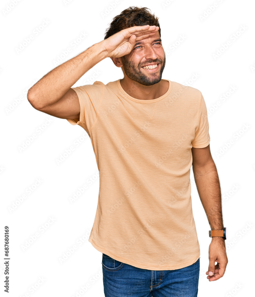 Poster Handsome young man with beard wearing casual tshirt very happy and smiling looking far away with hand over head. searching concept.