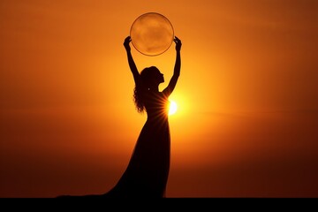 A woman's silhouette against the sunset, holding a transparent orb, creating a sense of wonder and the beauty of nature.