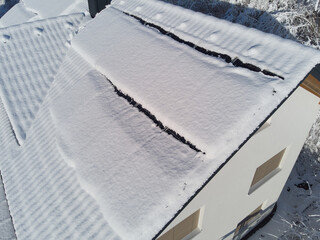 Solar Panels on Snow-Covered House Roof in Winter