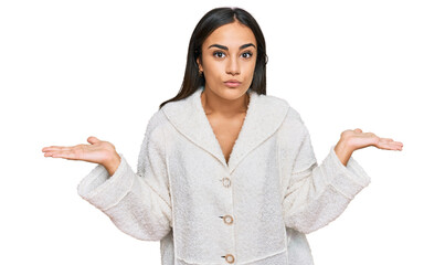 Young brunette woman wearing casual clothes clueless and confused expression with arms and hands...