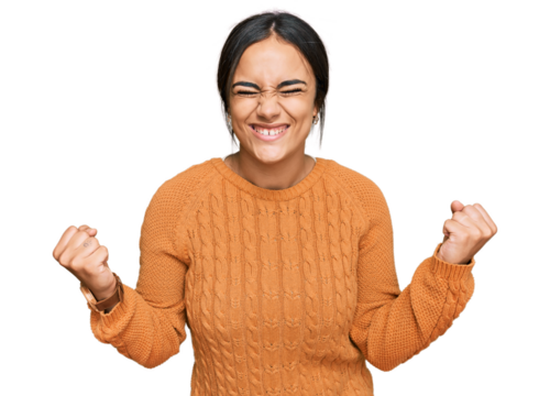 Young brunette woman wearing casual winter sweater very happy and excited doing winner gesture with arms raised, smiling and screaming for success. celebration concept. - Powered by Adobe