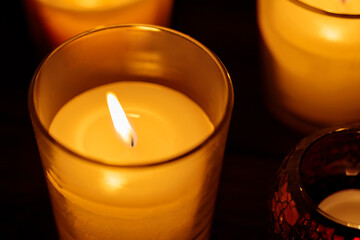 Aromatic Candles in Glass: Warm Glow on Dark Background, Close-up