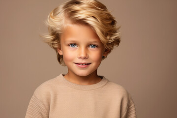 A young boy with blonde hair and blue eyes smiles for the camera