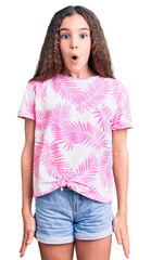 Fototapeta premium Cute hispanic child girl wearing casual clothes afraid and shocked with surprise expression, fear and excited face.