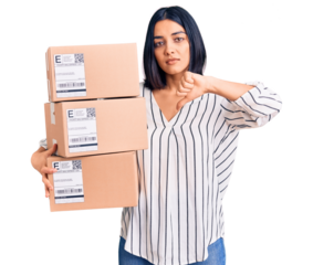 Young beautiful latin woman holding delivery package with angry face, negative sign showing dislike with thumbs down, rejection concept