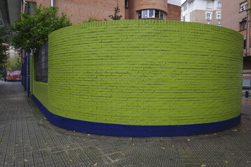 Colorful brick wall background in the corner of a street in the city of Bilbao in a cloudy day