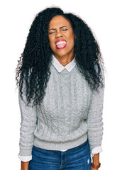 Middle age african american woman wearing casual clothes sticking tongue out happy with funny expression. emotion concept.