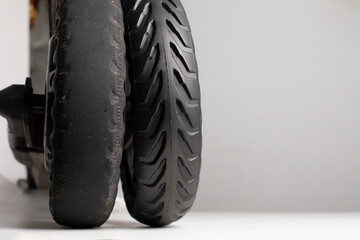 Old worn out tire versus new tire, replacement of a hard solid rubber tire for electric scooter...