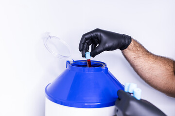 Close up of the hands of a nurse putting a test tube with blood in a centrifuge to separate plasma from blood. PRP therapy for rejuvenation. Platelet rich plasma.