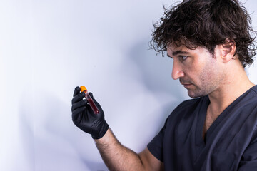 Doctor looking at a blood sample tube before taking it for analysis.