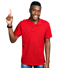 Young african american man wearing casual red t shirt pointing finger up with successful idea. exited and happy. number one.